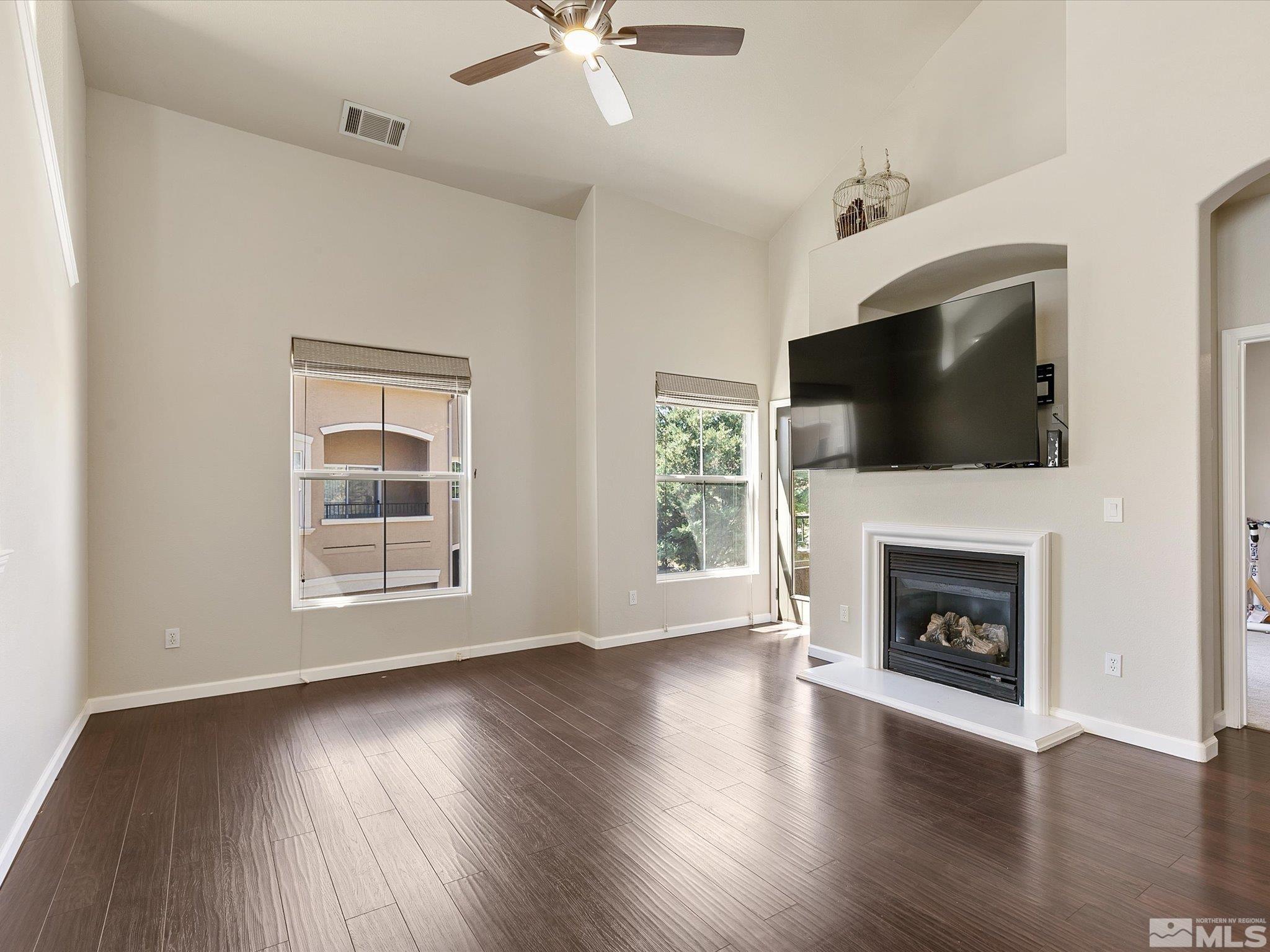 9050 Double R Boulevard, Unit 923 Reno, NV 89521 - Photo 10 of 10 an empty room with wooden floor fireplace and windows