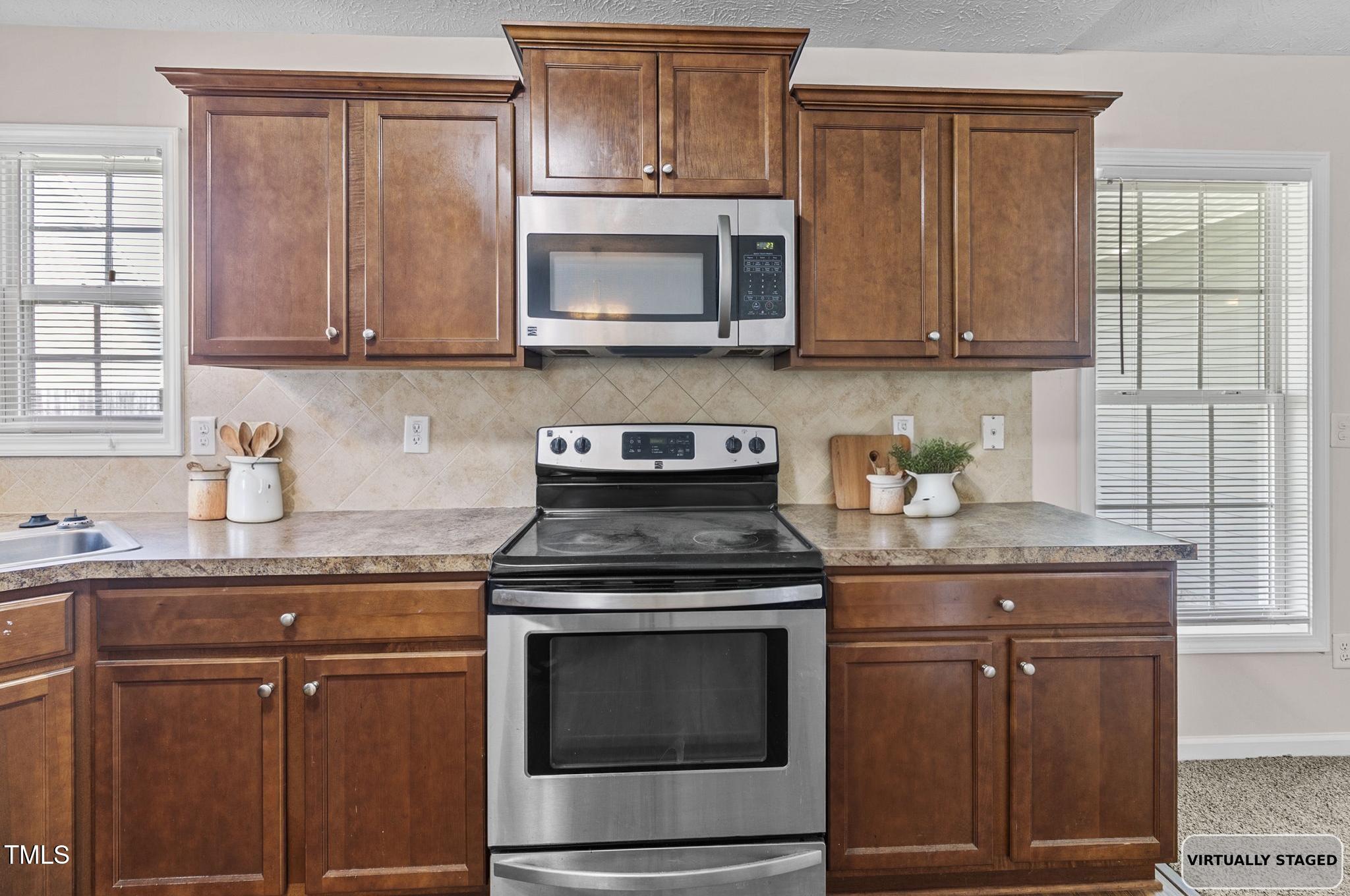 2513 Hunting Bow Drive Hope Mills, NC 28348 - Photo 10 of 39 a kitchen with granite countertop white cabinets and stainless steel appliances