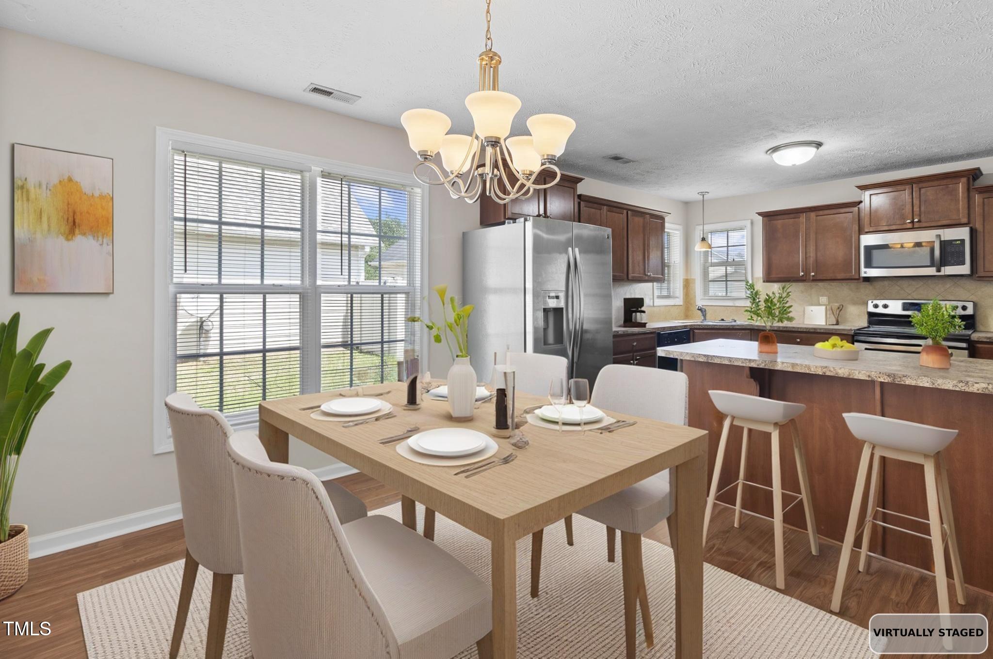 2513 Hunting Bow Drive Hope Mills, NC 28348 - Photo 15 of 39 a view of a dining room with furniture a chandelier and wooden floor