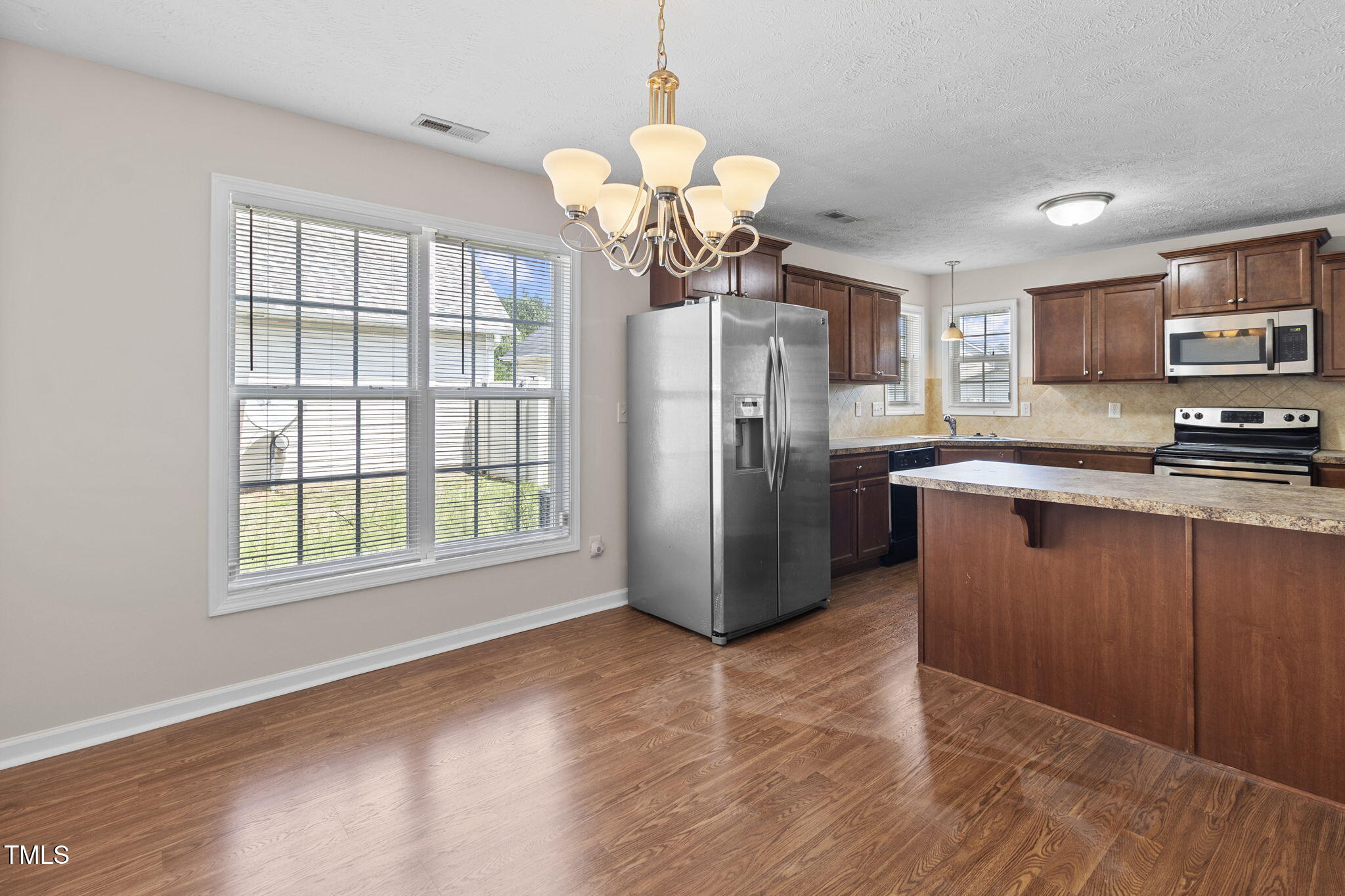 2513 Hunting Bow Drive Hope Mills, NC 28348 - Photo 16 of 39 a kitchen with stainless steel appliances granite countertop a refrigerator a sink a stove a microwave and island