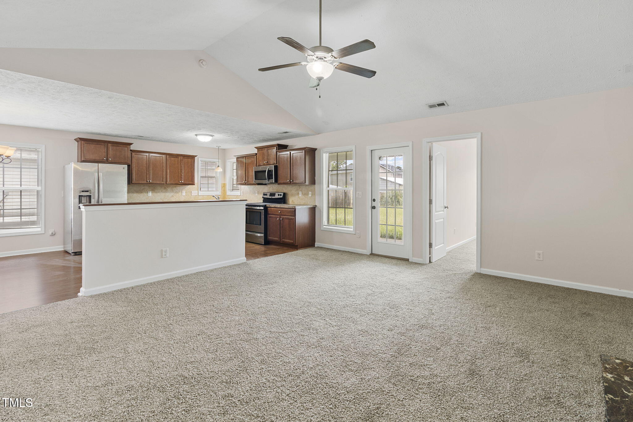 2513 Hunting Bow Drive Hope Mills, NC 28348 - Photo 7 of 39 a view of a kitchen with a stove cabinets a ceiling fan and wooden floor