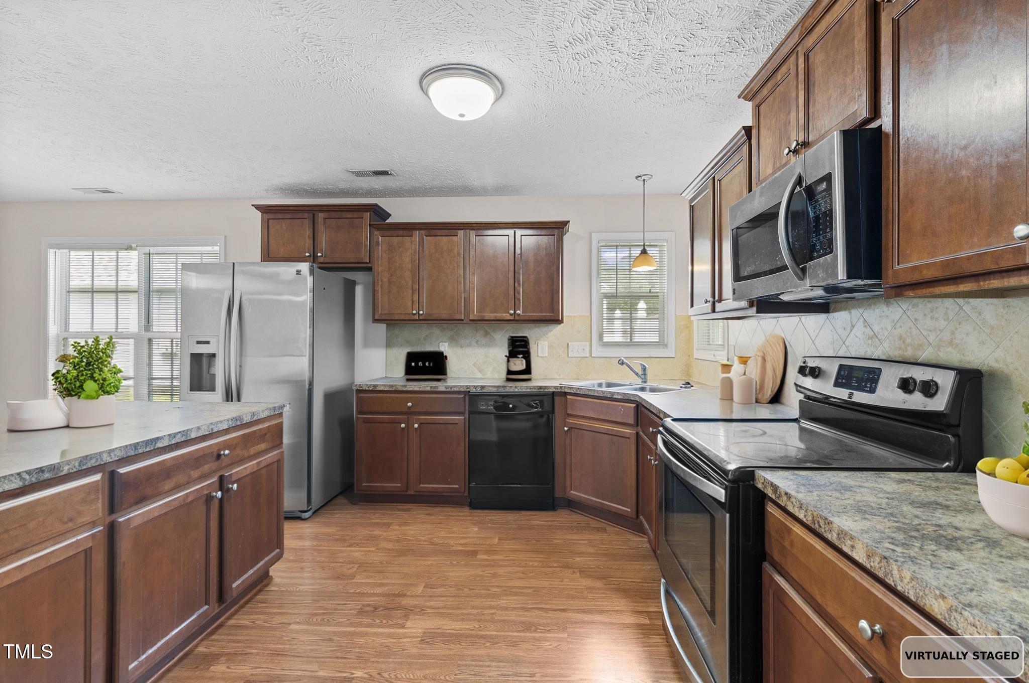2513 Hunting Bow Drive Hope Mills, NC 28348 - Photo 8 of 39 a kitchen with stainless steel appliances granite countertop a sink stove microwave and refrigerator