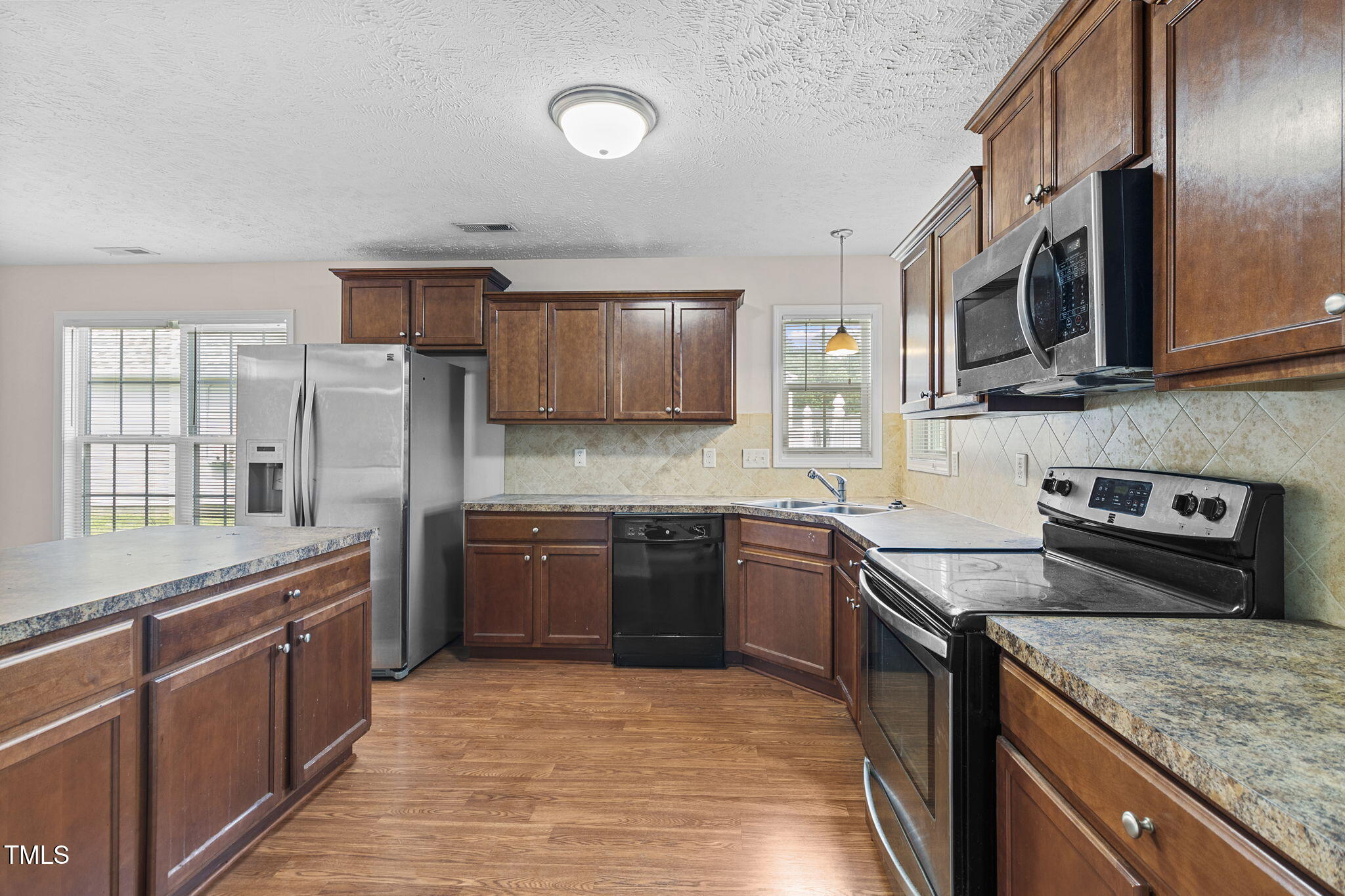 2513 Hunting Bow Drive Hope Mills, NC 28348 - Photo 9 of 39 a large kitchen with stainless steel appliances granite countertop a stove sink and cabinets