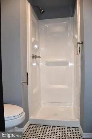a bathroom with a toilet and a shower