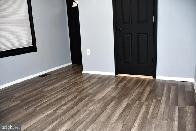 a view of an empty room with wooden floor