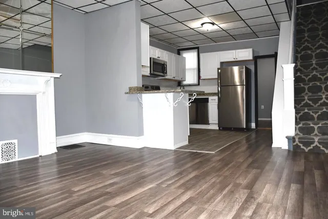 a view of a kitchen with a sink and a refrigerator