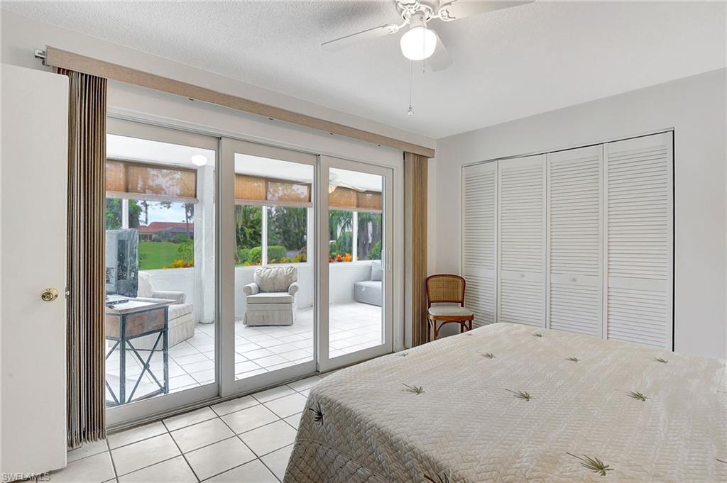 191 Quails Nest Road, Unit 1 Naples, FL 34112 - Photo 14 of 46 a bedroom with a bed and a large window with outer view
