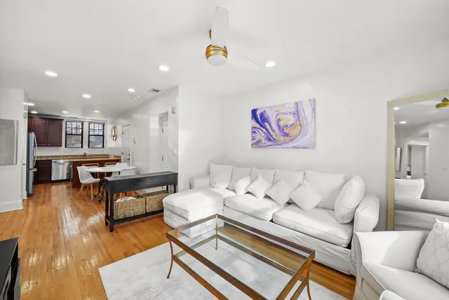 a living room with furniture and kitchen view