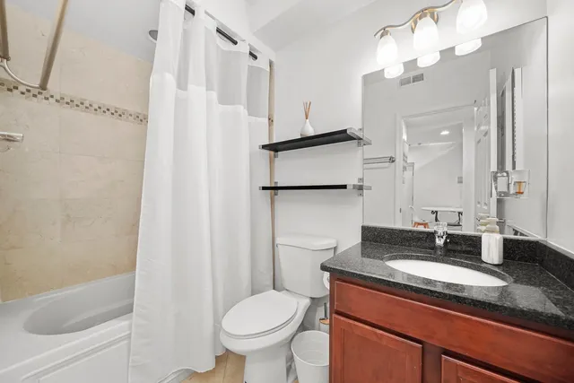 a bathroom with a granite countertop sink toilet and shower