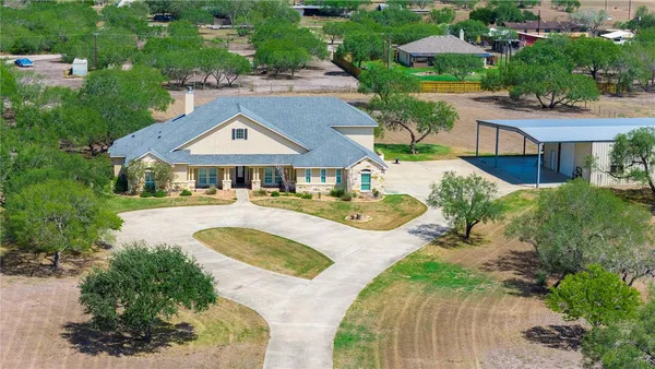 an aerial view of a house with swimming pool and garden