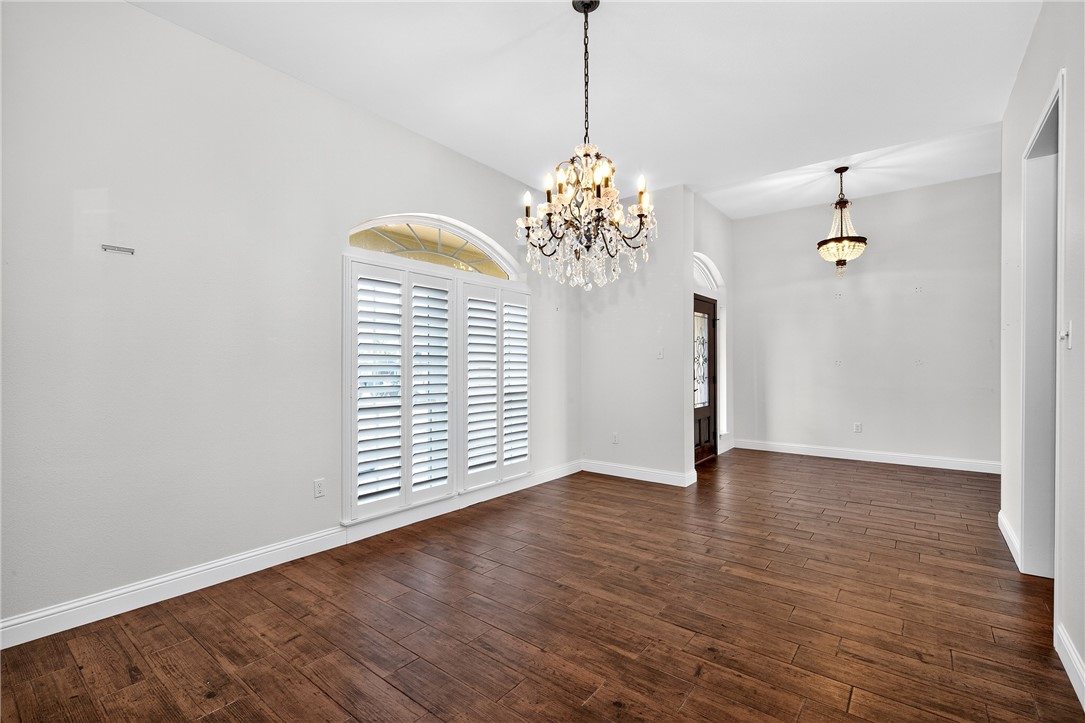 5332 Alegre Lane Robstown, TX 78380 - Photo 17 of 40 a view of an empty room with wooden floor and a chandelier