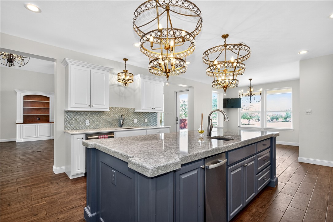 5332 Alegre Lane Robstown, TX 78380 - Photo 21 of 40 a kitchen with stainless steel appliances granite countertop a sink dishwasher a stove a dining table and chairs with wooden floor