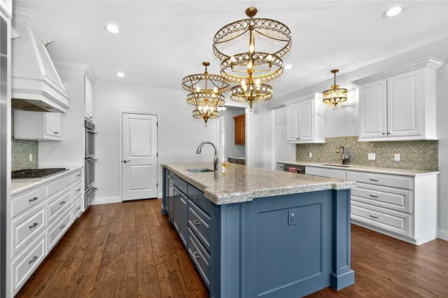 a kitchen with stainless steel appliances granite countertop a sink a stove cabinets counter space and a window