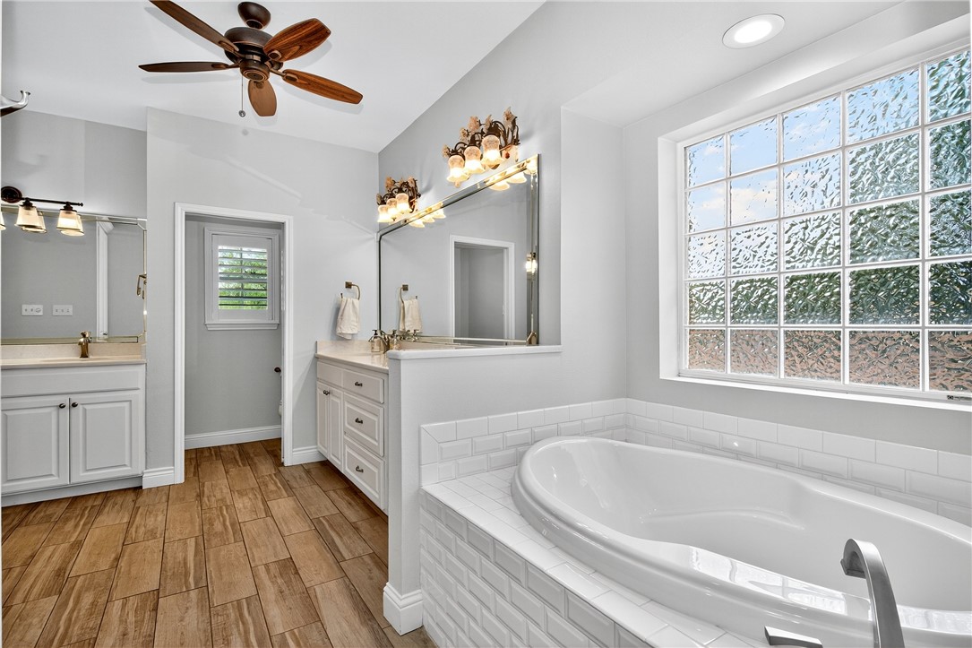 5332 Alegre Lane Robstown, TX 78380 - Photo 30 of 40 a bathroom with a double vanity sink a mirror and a bathtub