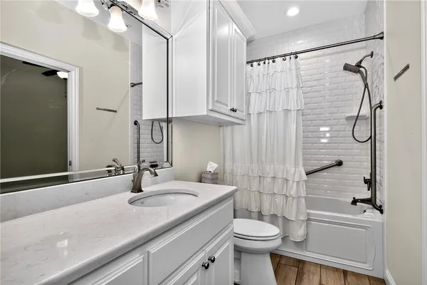 a bathroom with a sink a toilet and shower