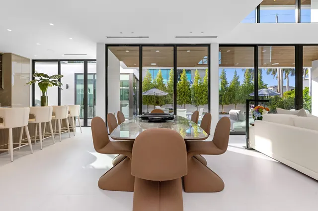 a dining table with chairs and kitchen view