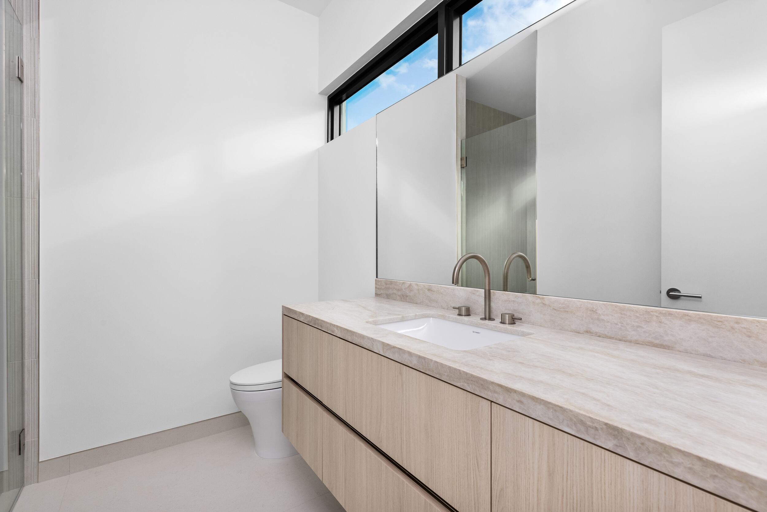 1099 Northeast 4th Avenue Boca Raton, FL 33432 - Photo 49 of 60 a bathroom with a granite countertop sink a toilet and a mirror
