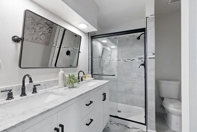 a bathroom with a sink a toilet and shower