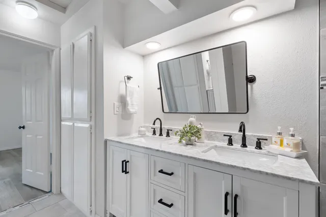 a bathroom with a double vanity sink and a mirror