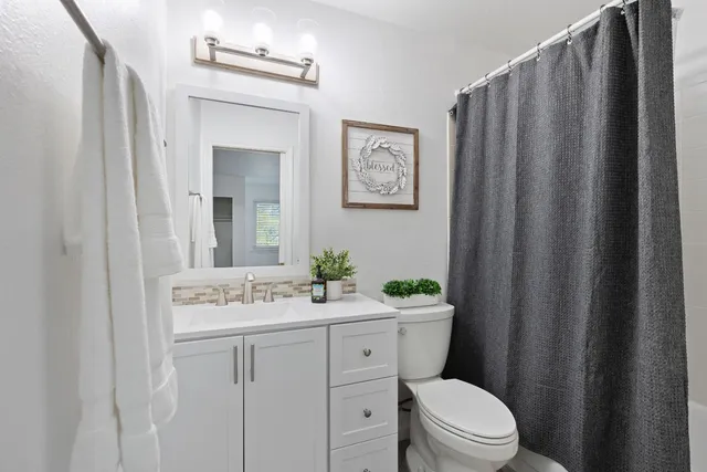 a bathroom with a sink a toilet and mirror