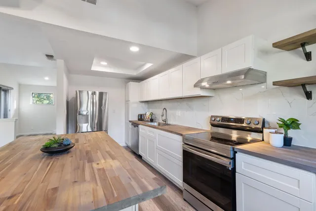a kitchen with stainless steel appliances granite countertop a sink dishwasher stove and oven