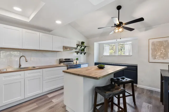 a kitchen with a table chairs cabinets and wooden floor