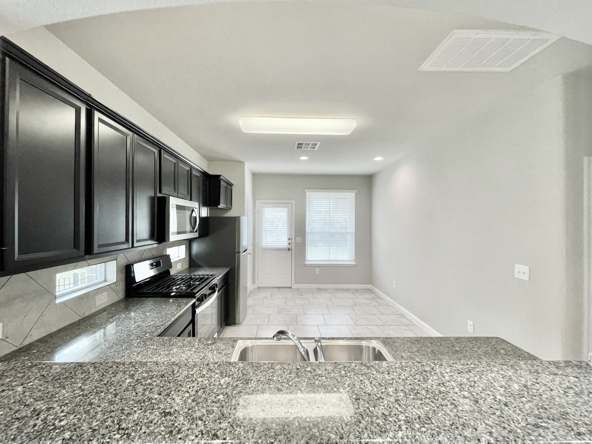 407 Rhetoric Way Pflugerville, TX 78660 - Photo 7 of 38 a living room with stainless steel appliances granite countertop furniture a rug and a window