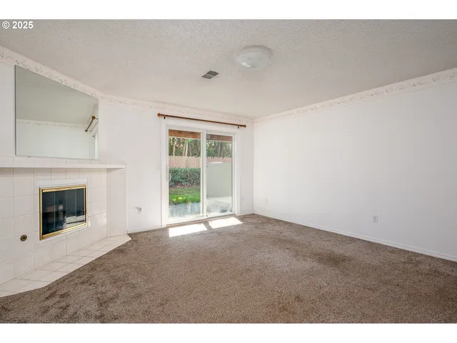 a view of a livingroom with wooden floor and a fireplace