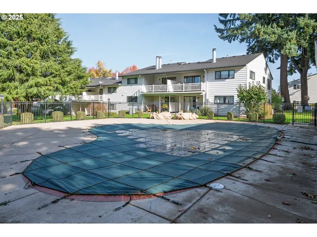 a view of an house with backyard and trees
