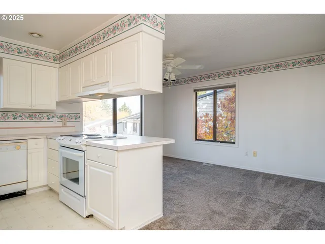 a kitchen with granite countertop white cabinets and white appliances