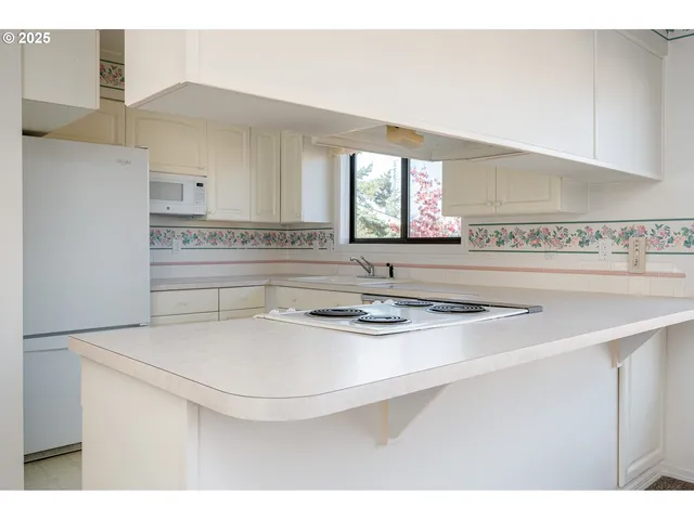 a kitchen with kitchen island a sink a stove and a refrigerator