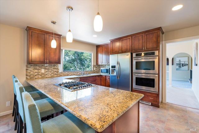 a kitchen with kitchen island a sink stainless steel appliances and window