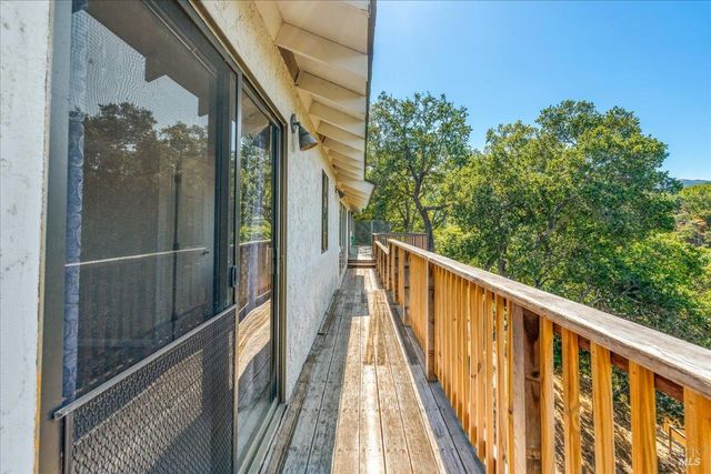 a view of a balcony with wooden floor and fence
