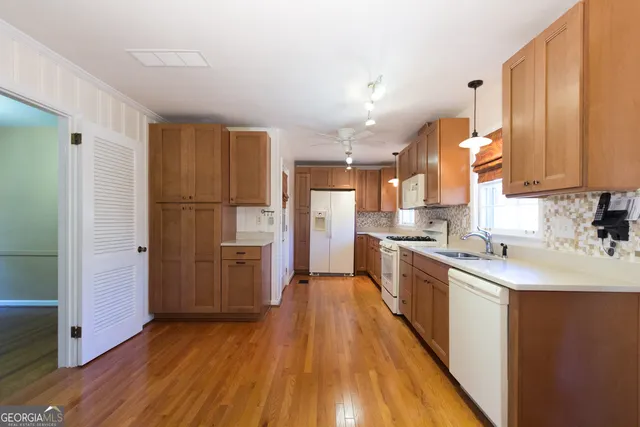 a kitchen with kitchen island wooden floors appliances and cabinets