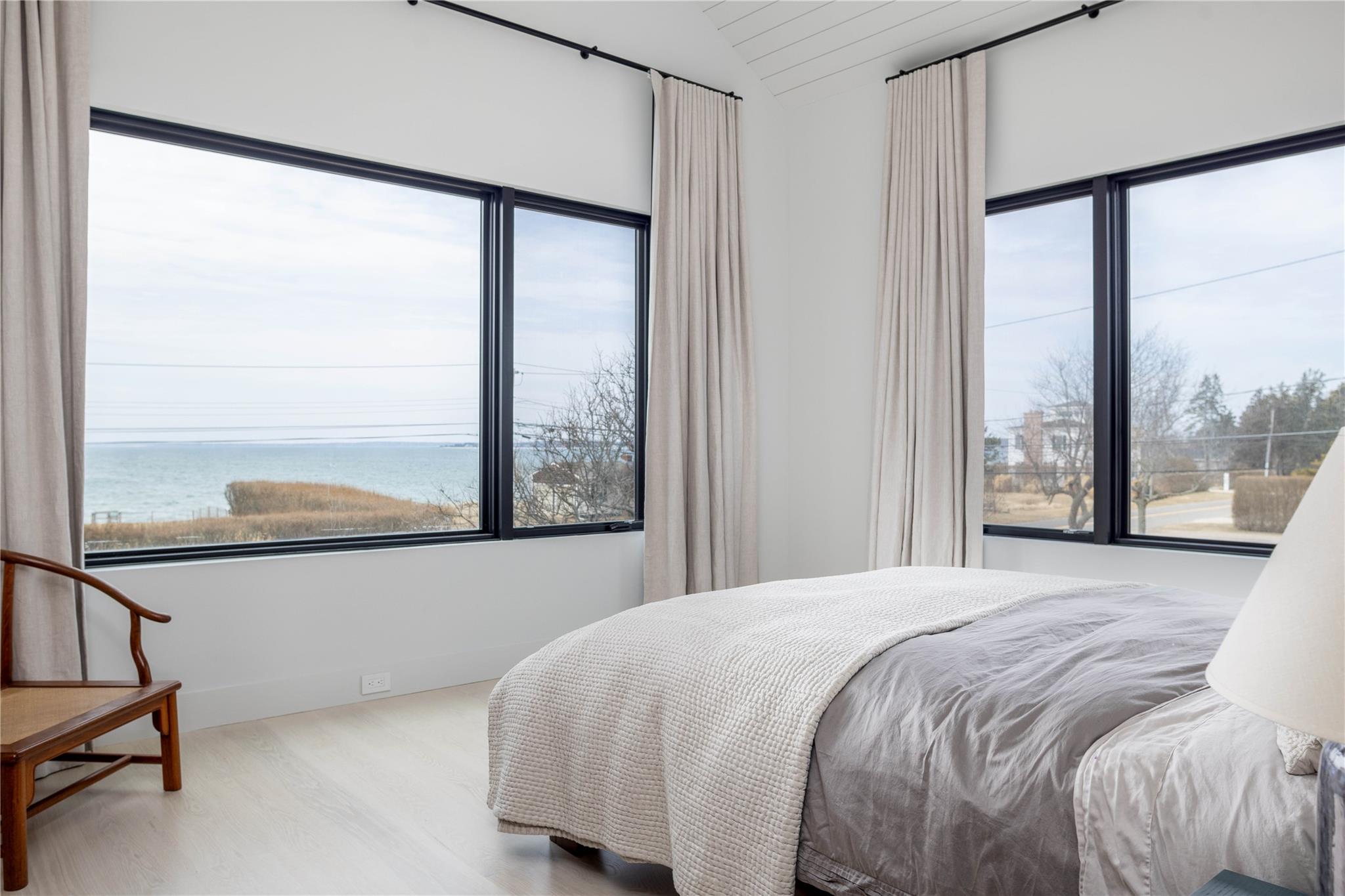 61 Peconic Avenue Shelter Island Heights, NY 11964 - Photo 14 of 27 a bedroom with a large window and a bed