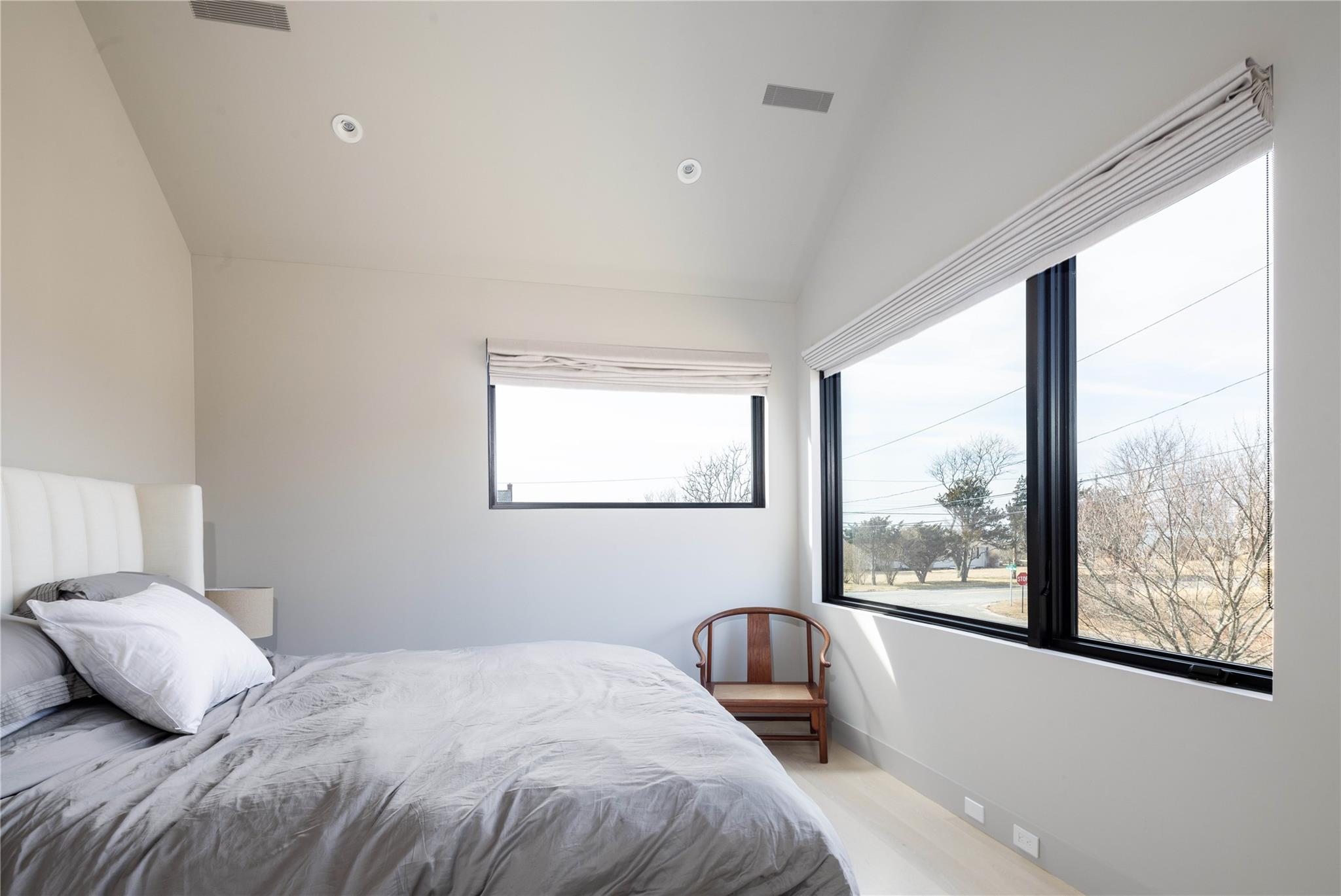 61 Peconic Avenue Shelter Island Heights, NY 11964 - Photo 18 of 27 a bedroom with a large bed and a large window