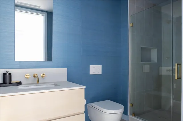 a bathroom with a sink a toilet and shower