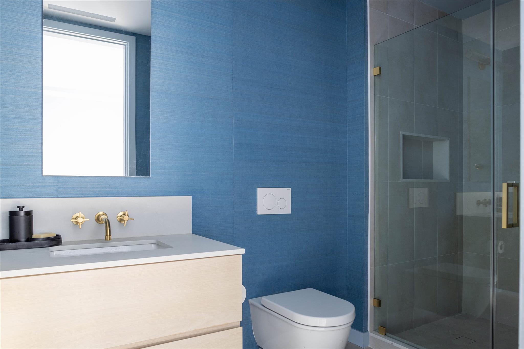 61 Peconic Avenue Shelter Island Heights, NY 11964 - Photo 23 of 27 a bathroom with a sink a toilet and shower