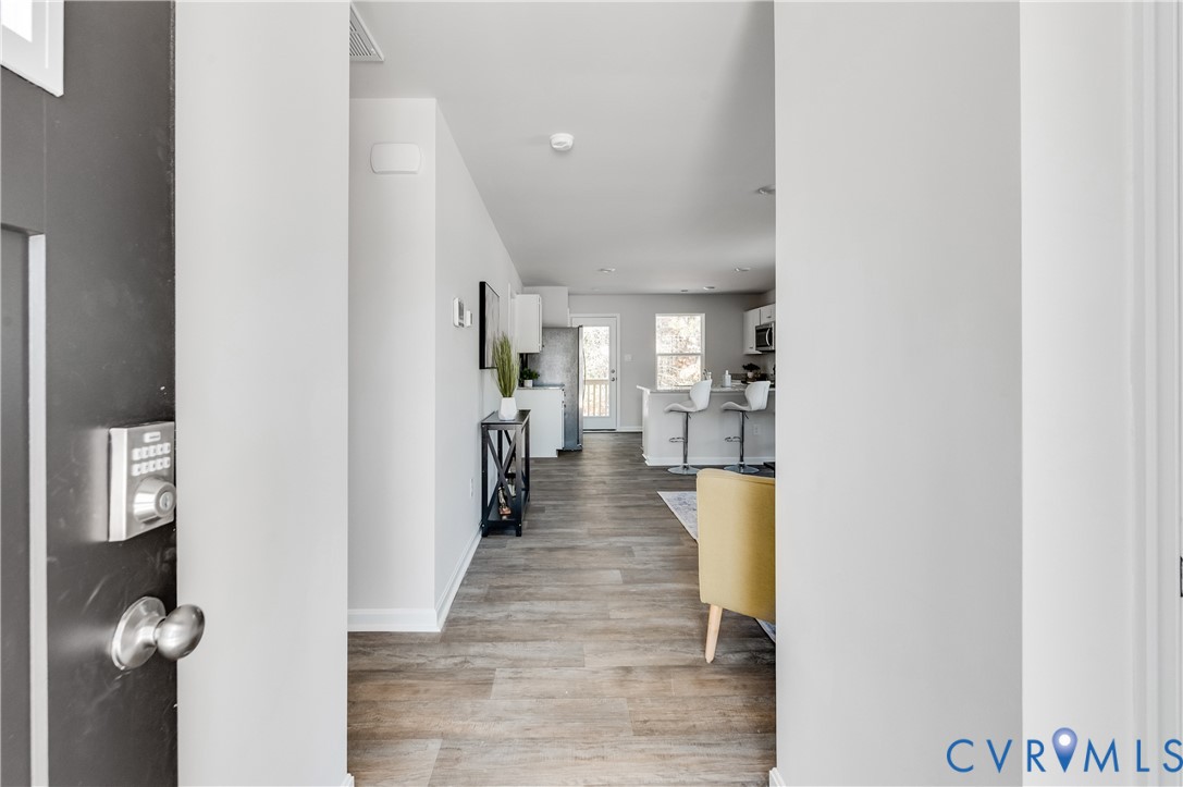 101 Our Way Drive Kilmarnock, VA 22482 - Photo 7 of 38 a hallway with wooden floor and a living room