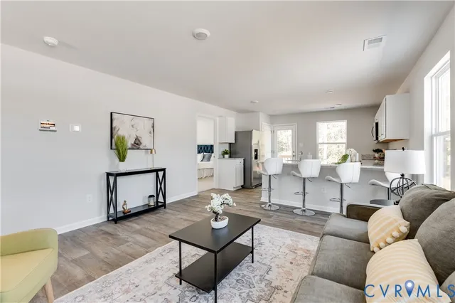 a living room with furniture and wooden floor