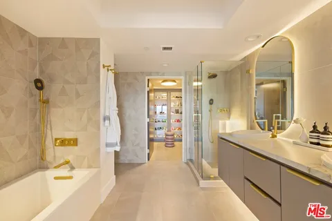 a spacious bathroom with a tub sink shower and mirror