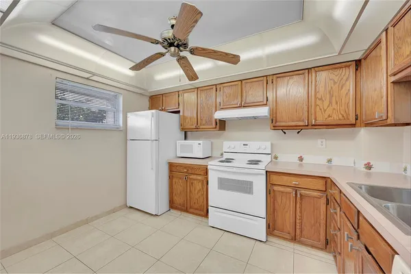 a kitchen with a sink a refrigerator and cabinets