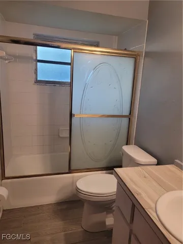 a bathroom with a granite countertop toilet a sink and mirror
