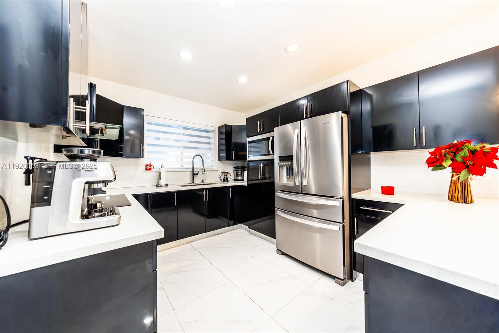 9365 Southwest 44th Street Miami, FL 33165 - Photo 11 of 24 a kitchen with stainless steel appliances a refrigerator sink stove microwave and cabinets