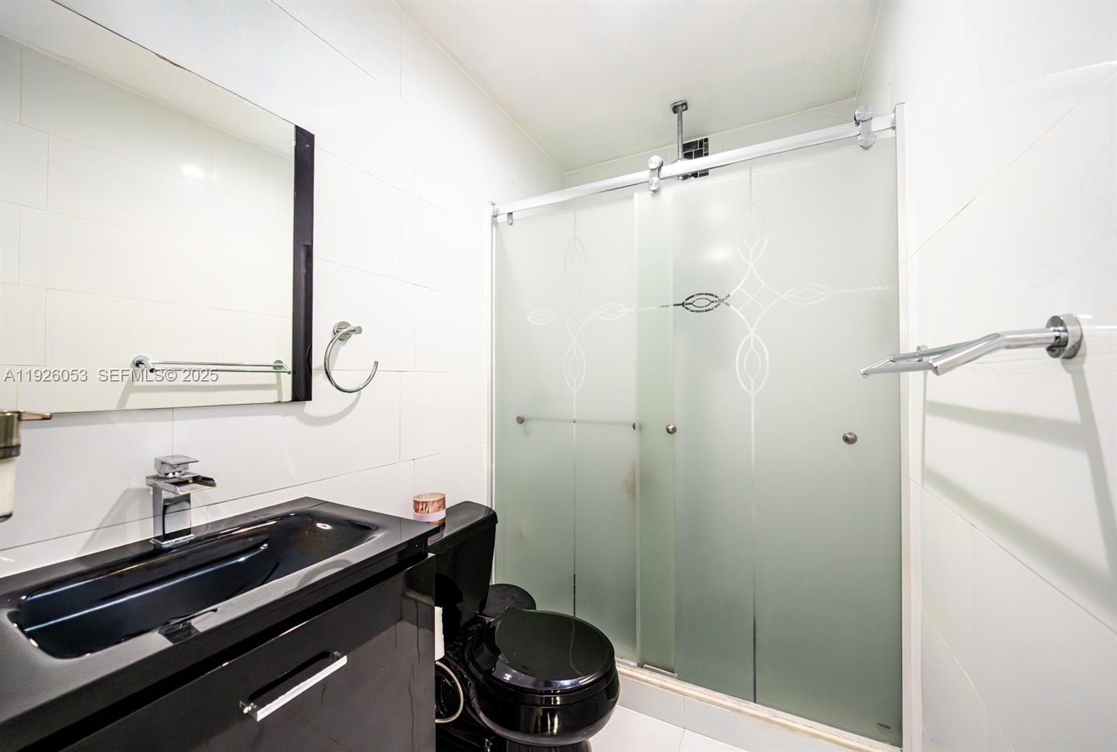 9365 Southwest 44th Street Miami, FL 33165 - Photo 14 of 24 a bathroom with a sink and a mirror