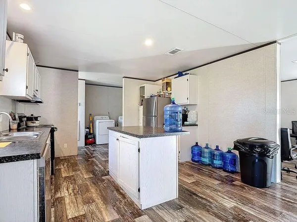 a kitchen with granite countertop white cabinets and white appliances