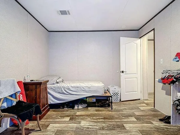 a bedroom with a bed and a flat tv screen on the dresser
