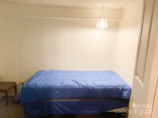 a bed sitting in a bedroom next to a small window