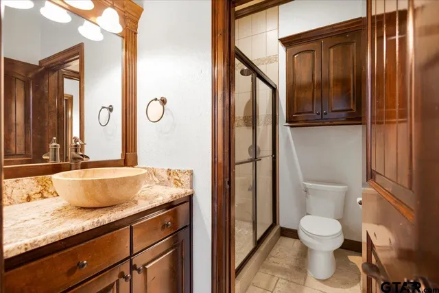 a bathroom with a granite countertop sink toilet and shower