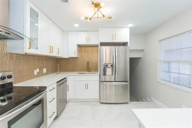 a kitchen with stainless steel appliances a refrigerator sink and cabinets